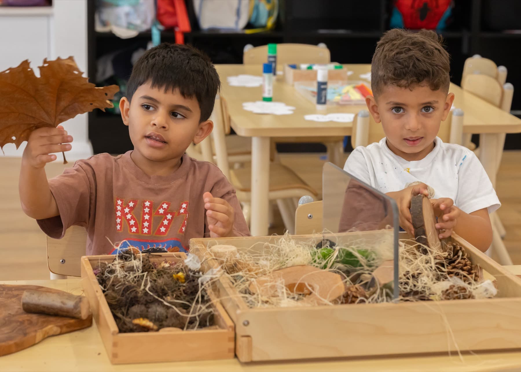 Children exploring leaves and natural materials