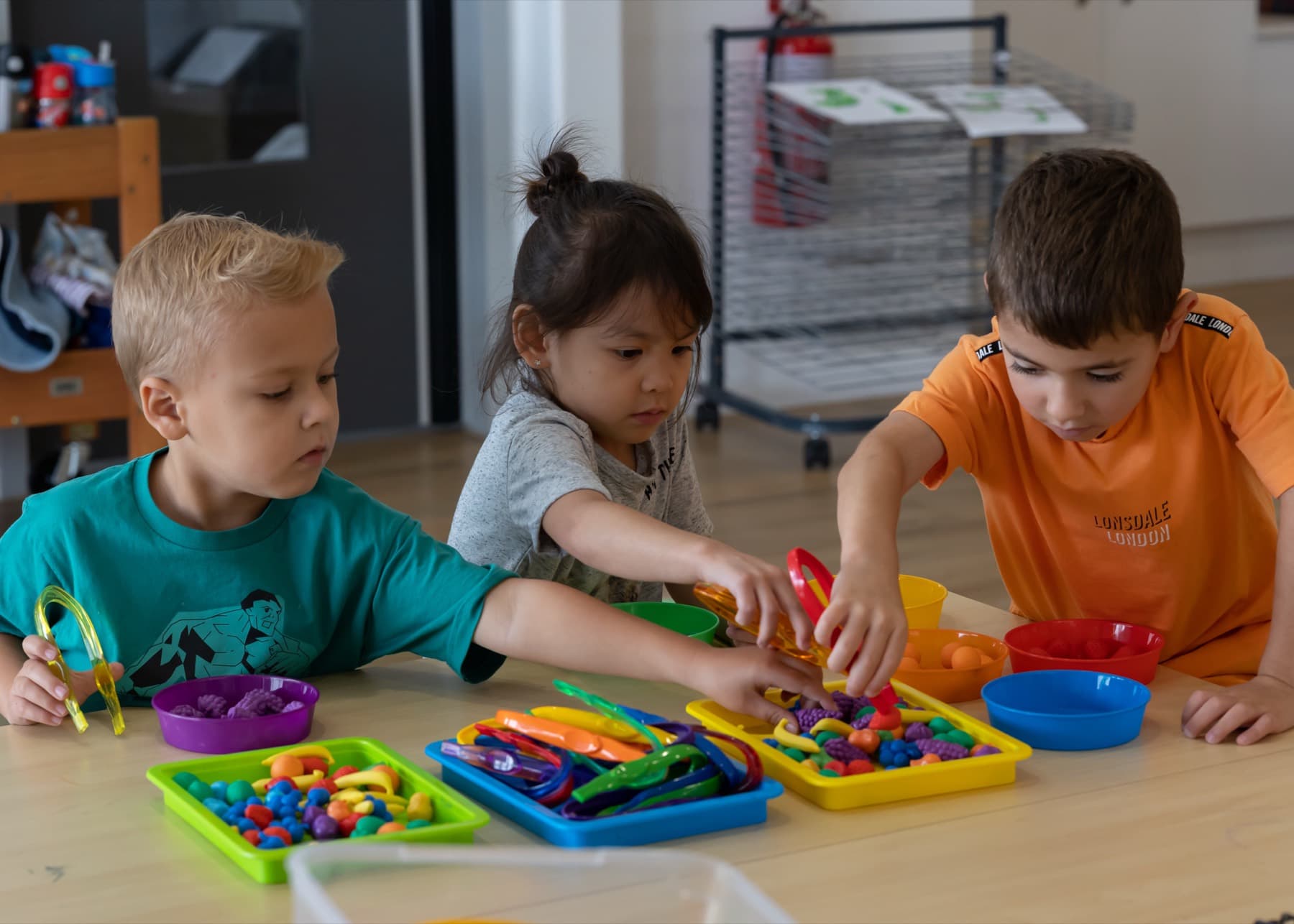 Children sorting colourful pieces at a table