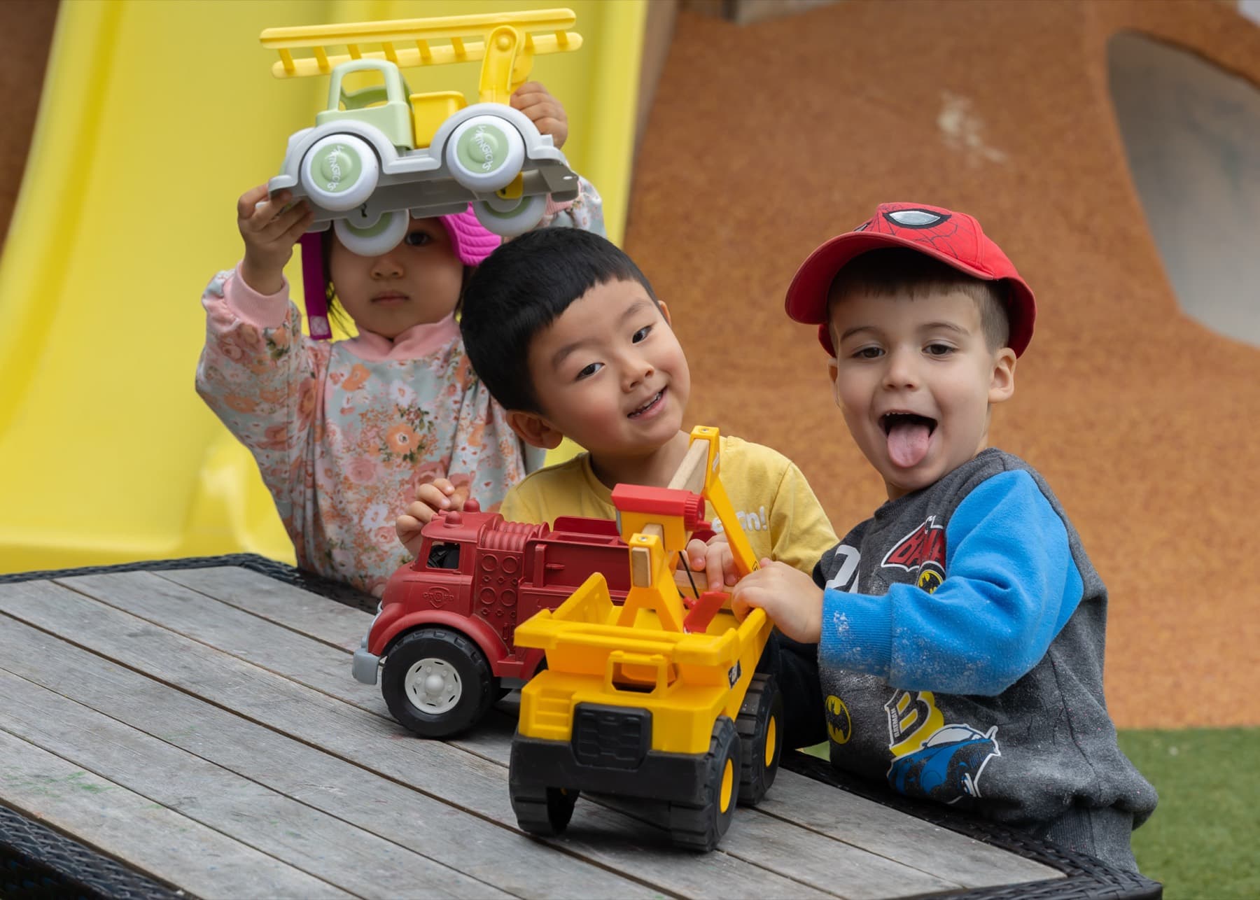 Children laughing together over toy trucks