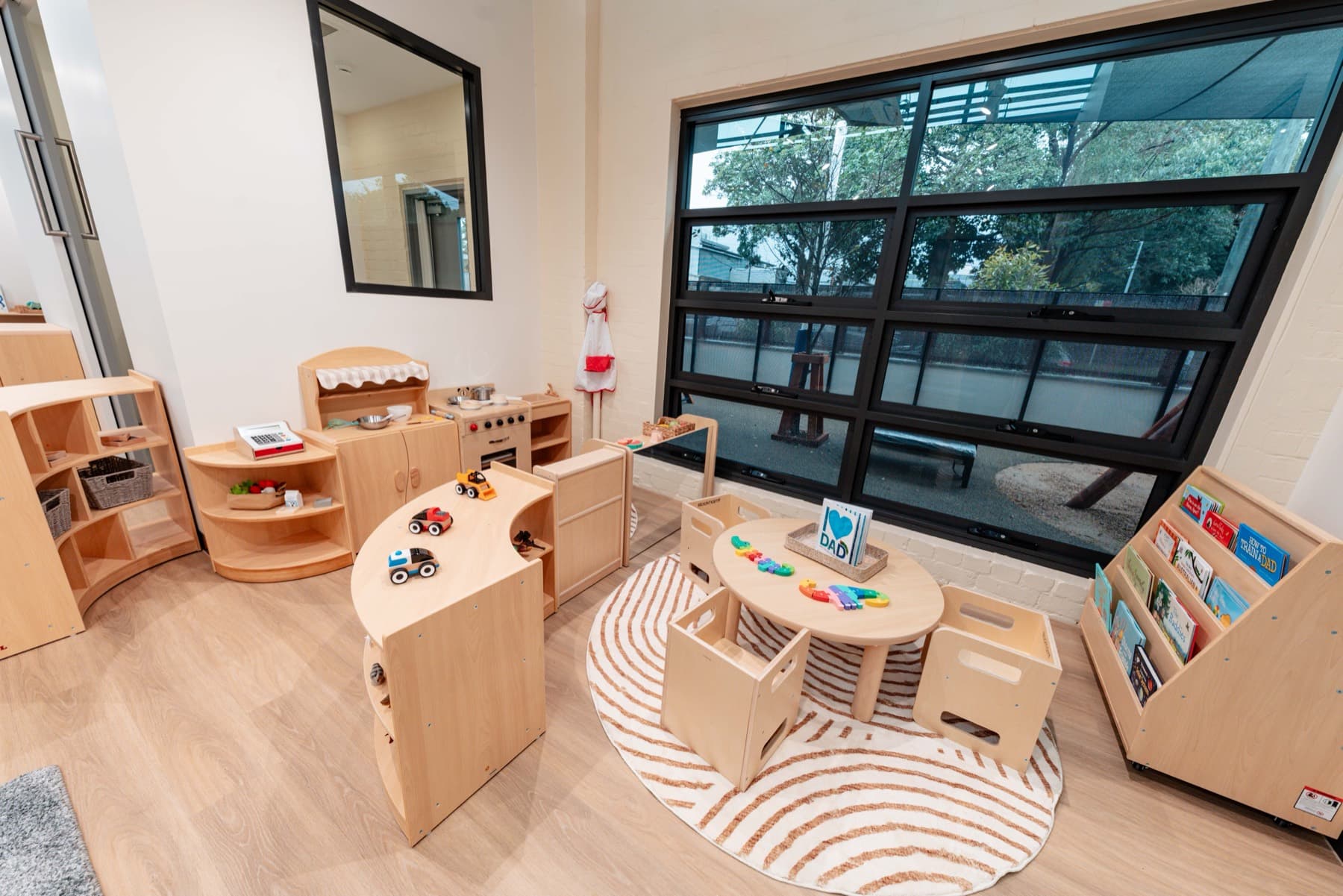 A room at Rosebery with timber furniture under black steel windows