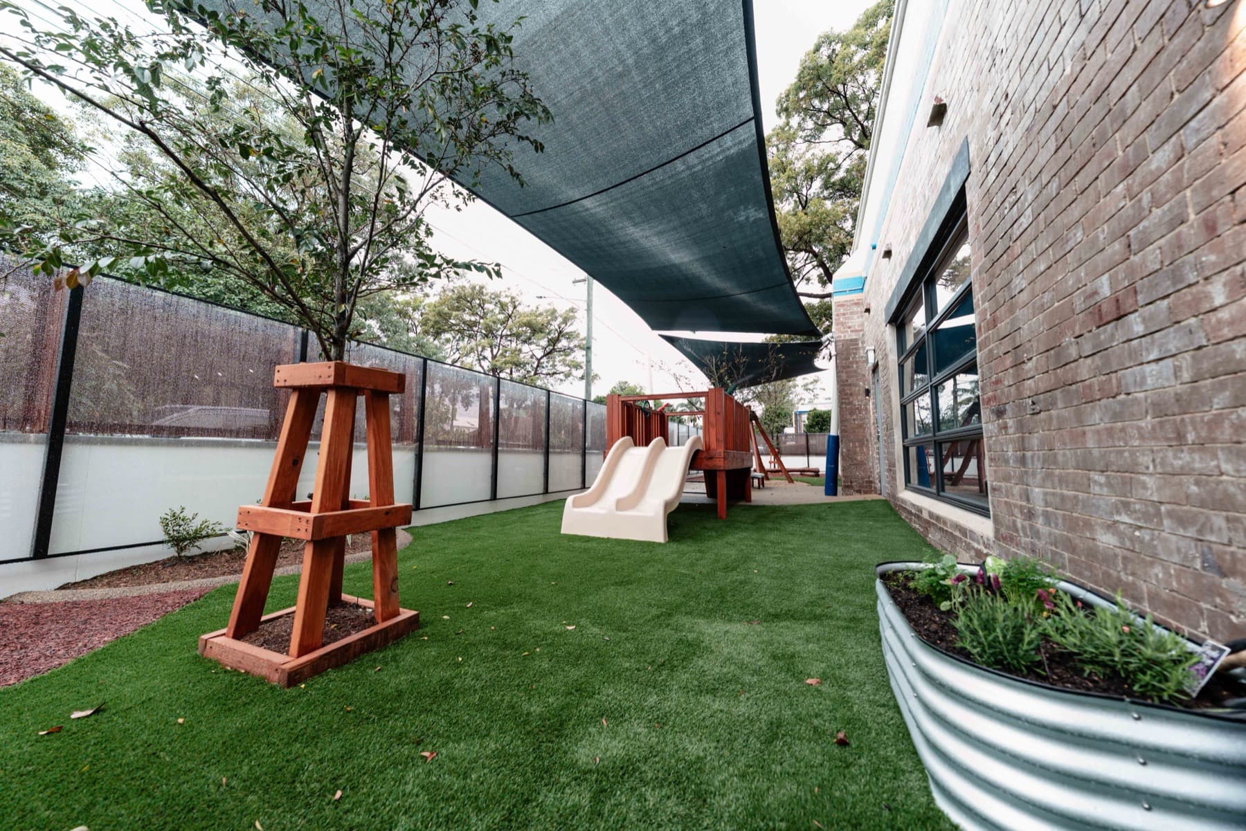 The outdoor play area with a timber cubby